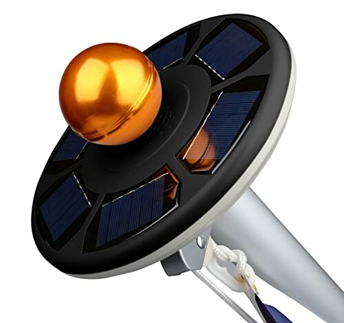 Solar-powered flagpole light with a golden sphere on top.